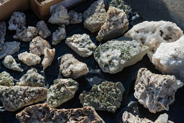 Collection of various uncut gemstones on a table. Close up of minerals.