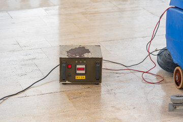 Old transformer to charge battery on, sweeper on stone floor.