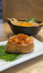 Inarizushi with salmon sashimi topping with Japanese Saikyo sauce