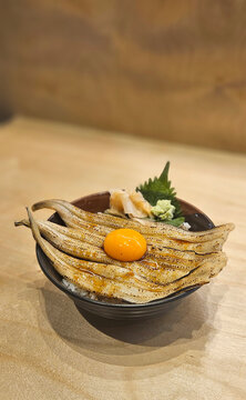 Grilled anago Japanese saltwater eel with raw egg topping with Japanese rice.