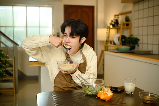 Young asian man enjoying healthy breakfast at home