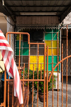 Yellow and green glass wall color pattern and brown entrance gate with Malaysian flag, Malaysia