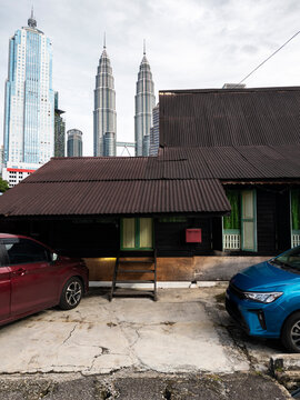 Wooden house and twin Petronas toers  architectural contrast, Kuala Lumpur, Malaysia