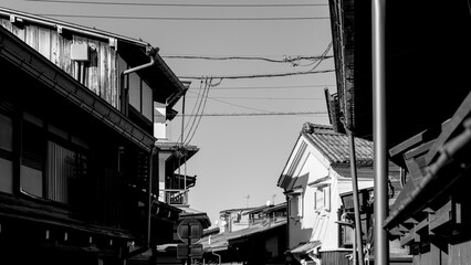 Obraz premium Monochrome street scene in Takayama historic Kamisannomachi district with visible power lines, old wooden buildings, and sharp contrast under daylight
