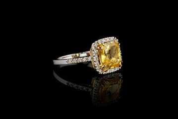 white gold ring with yellow sapphire stone, diamonds on black background