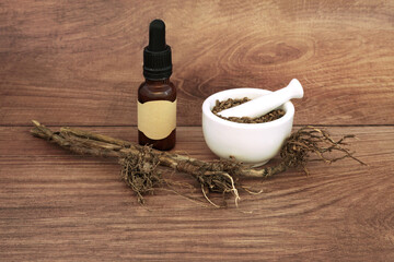 Valerian herb root preparation for herbal medicine with mortar. Treats insomnia, stress, anxiety, digestive health, menstrual cramps. Alternative nature healing.
