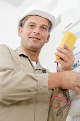 electrician measuring voltage in distribution board closeup