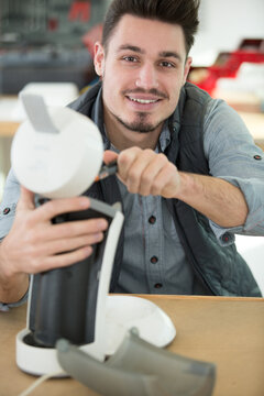 professional young worker fixing coffee machine
