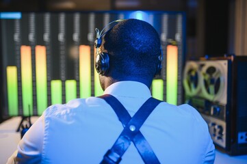 Secret agent listens on the reel tape recorder. Officer wiretapping in headphones