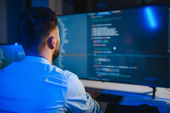 Portrait of male programmer in office at night