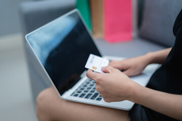 Woman holding credit card, paying with credit card, with laptop, online shopping concept