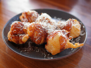 selective focus of Fried bananas topped with chocolate and cheese on wooden table.Close up of Fried bananas