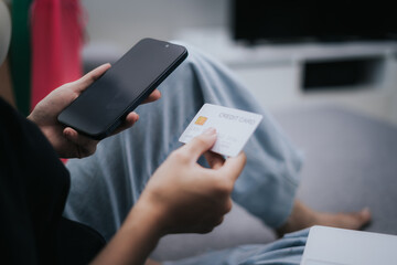 Woman holding credit card and mobile phone