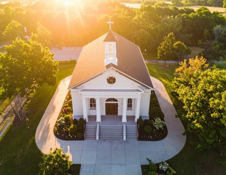 Aerial view of a traditional church with sunlight and green surroundings