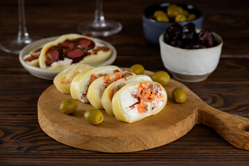 Farm cheese with salmon, olives, cream cheese, dates, freeze-dried strawberries on a wooden table with wine. Healthy rustic breakfast.