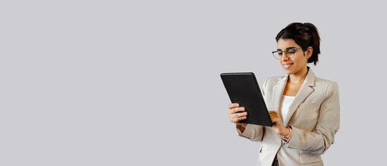 Focused latin or arab office hr manager woman working holding touchscreen tab computer isolated. Young indian female entrepreneur, financial bank manager using tablet app for work. Banner, copy space