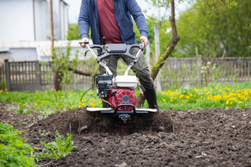 Farmer using tiller on a plowed field