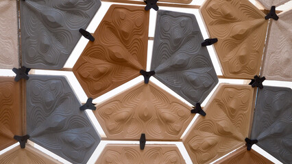 Geometric ceramic wall tiles with embossed topographic patterns in earthy tones—modern modular...