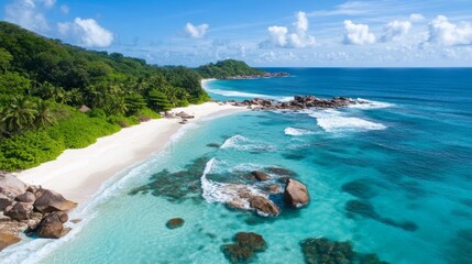 Fototapeta premium A photo from above shows a white sandy beach with rocks, waves, and clear blue water on a sunny island. Perfect for a summer trip! 
