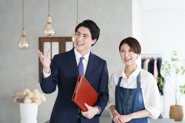 物件案内する不動産営業マンと開業する女性