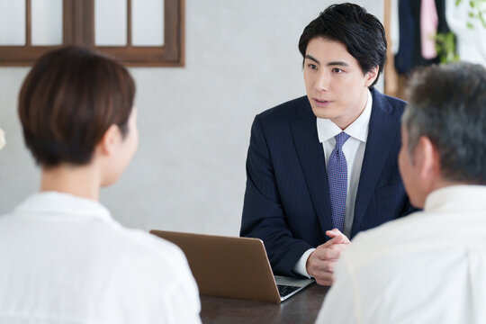 打ち合わせする営業マンと親子の客