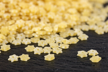 Fototapeta premium Dry star shaped stelline pasta close-up. World Paste Day concept