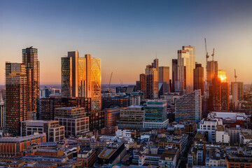 Panoramic view of the London City skyline with soft sunset light reflections in the glass facades of the modern office skyscrapers