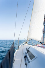 Fototapeta premium Sailing on a sunny day: jib and mast on a sailboat navigating the sea