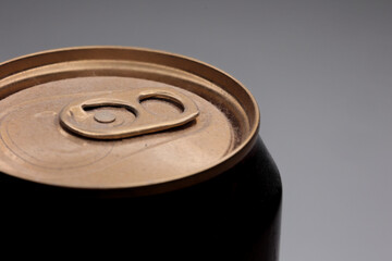 Angled Macro Close-Up Of The Dusty Golden Top Lid Of An Aluminum Beverage Can With Its Pull Tab, On A Smooth Neutral Grey Background. Minimalist Drink Concept.
