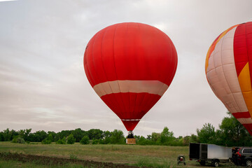 A vibrant aerostat balloon takes off and ascends into the sky