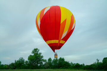 Naklejka premium A vibrant aerostat balloon takes off and ascends into the sky