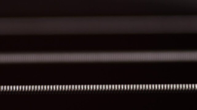 Close-up of buzzing vibrating strings on an untuned guitar, guitar tuning concept, string instrument sound