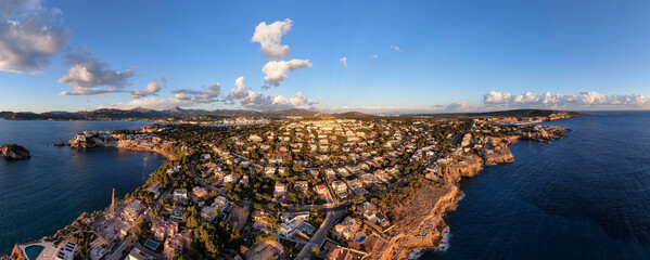Coastal town residential area stunning aerial panoramic photo surrounded by the sea sunlight illuminate building golden hour