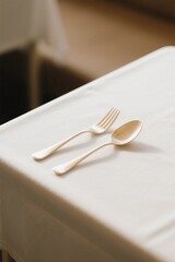 there is a fork and spoon on a table with a white tablecloth