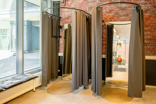 Modern fitting room with curtains and mirrors in stylish interior space