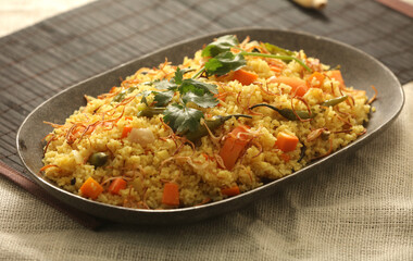 Spicy & hot Yellow Rice  with carrot, green chilly garnish with a wooden table mat