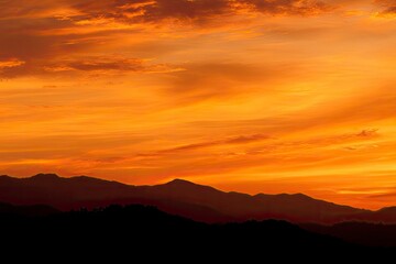 Fiery Sunset Over Silhouetted Mountains: A Dramatic Landscape