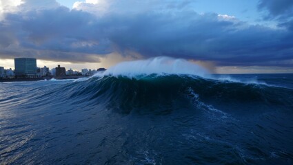 Fototapeta premium Massive Tsunami Wave Approaching Coastal City Under Stormy Sky – Photorealistic Natural Disaster Scene