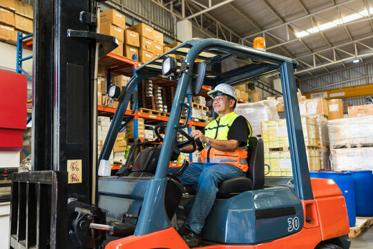 warehouse worker man forklift driver happy smiling enjoy staff working. asian male factory cargo shipping worker