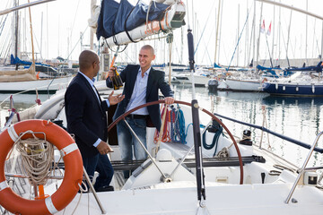 Men in suits relaxing on a yacht in the seaport