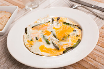 Closeup of fried eggs with asparagus at plate