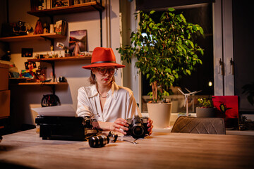 Stylish Woman Examining Vintage Camera at Desk