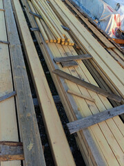 Various types of wooden planks stacked on a construction site during the day