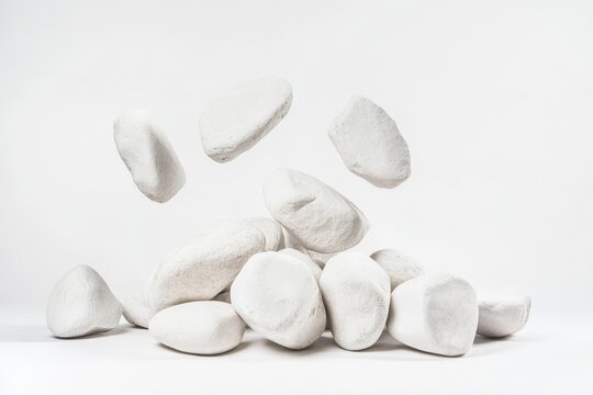 A collection of white angular stones is stacked in a modern arrangement, showcasing simplicity and elegance against a light backdrop