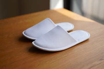 White Hotel Slippers on Wood Table