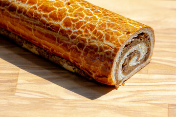 Selective focus of yeasted cake on wooden board, Hungarian sweet roll with a rich walnut filling, A...