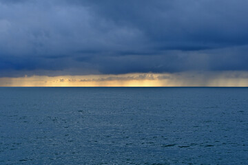 Obraz premium Stormy Sea Horizon with Rain and Dramatic Clouds