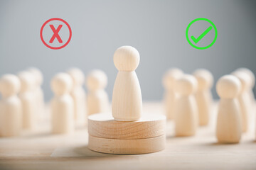 Wooden peg dolls atop a cube among others vote yes or no symbols. Reflects open-mindedness in...