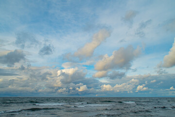 Dark sky over the sea. Low clouds over the water in the bay. Background with a tense panorama of nature before a storm at sunset.