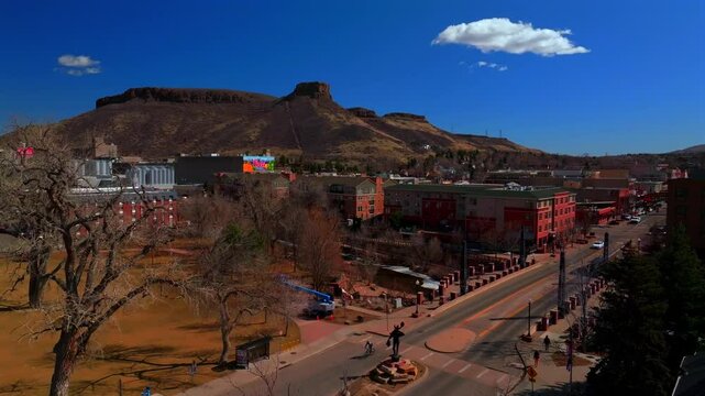Beautiful winter day sunny clouds historic downtown Golden Colorado aerial drone Coors Beer Factory North Table Mountain Mesa Clear Creek River park Golden Gate Canyon blue sky upwards motion